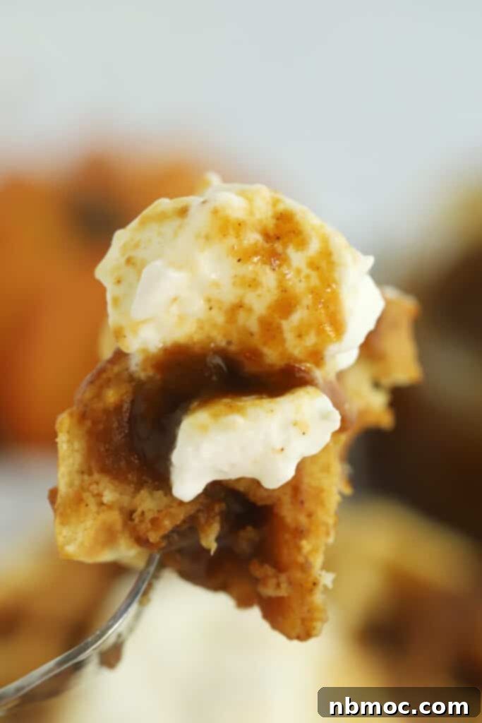 A fork with waffles covered in pumpkin syrup and whippe