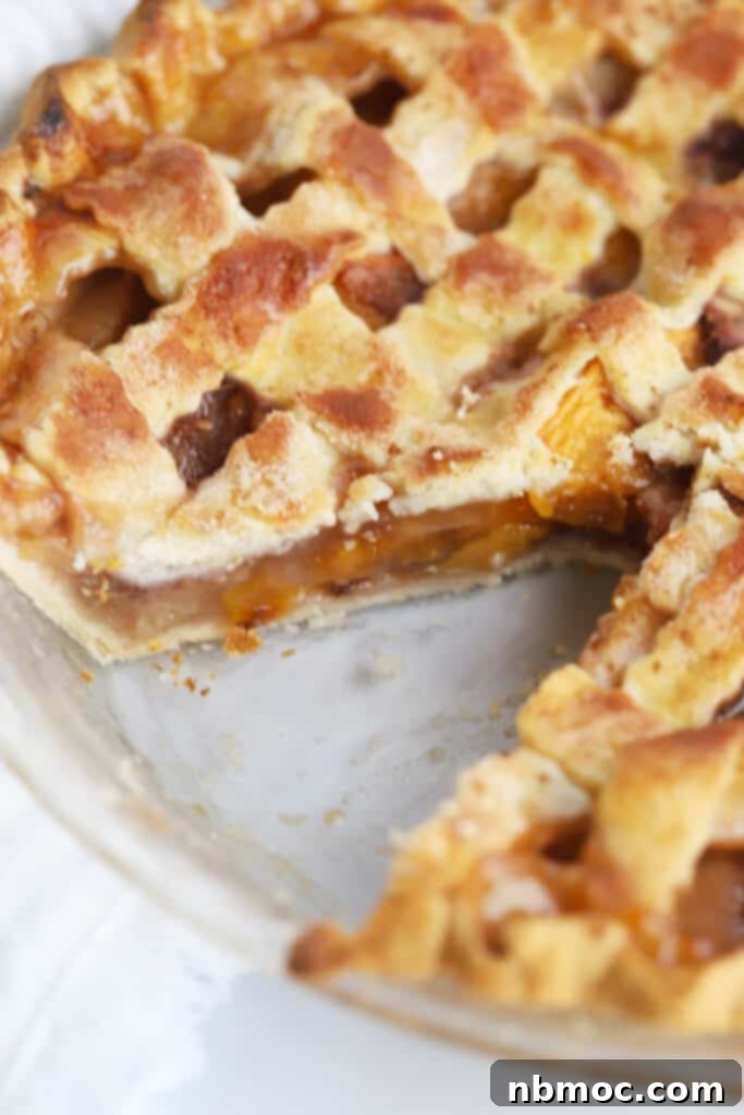 Sun-Kissed Peach Pie 3 This easy baked peach pie recipe in a pie plate with a slice removed.