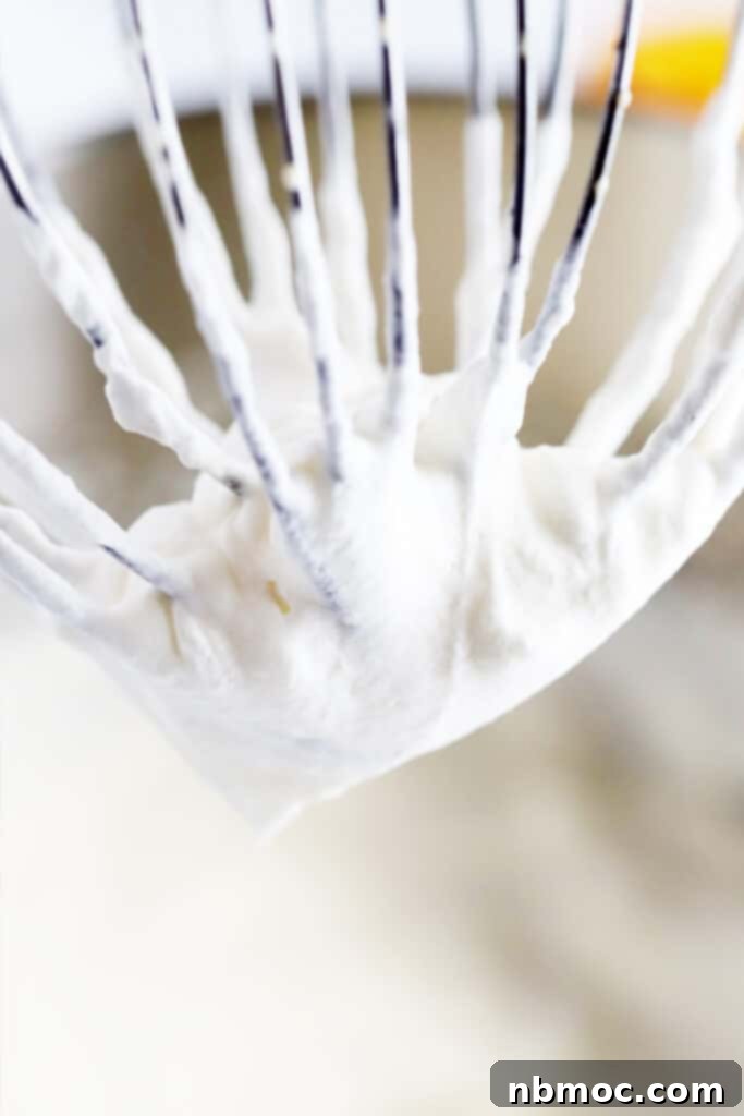 Homemade whipped cream clinging to a wire whisk.