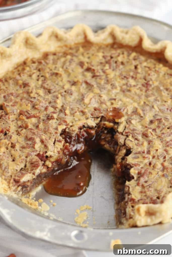 Decadent Caramel Pecan Bliss 3 A homemade Caramel Pecan Pie with a slice removed, revealing the rich, gooey caramel and toasted pecans within.