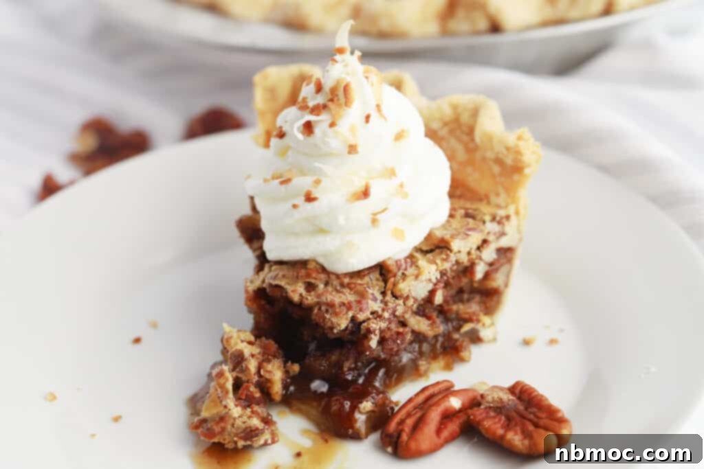 Decadent Caramel Pecan Bliss 7 A perfectly sliced pecan pie on a white plate, elegantly topped with homemade whipped cream and garnished with additional pecan pieces.