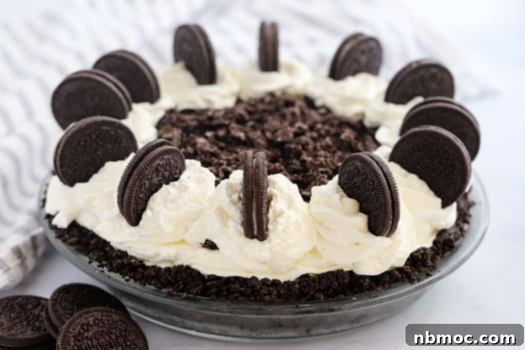 Velvety Chocolate Indulgence 3 A full Oreo choco Pie in a glass pie dish topped with whipped cream and decorated with Oreo cookies.