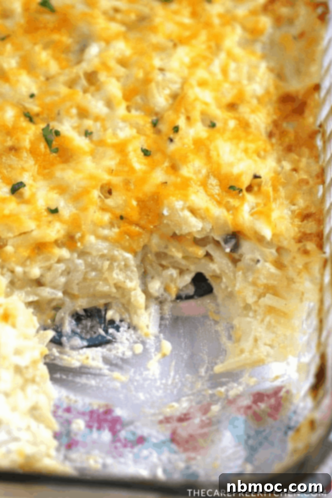 Ultimate Cheesy Potato Bake 2 cheesy potato casserole in a glass baking dish, an easy cheesy potato recipe.