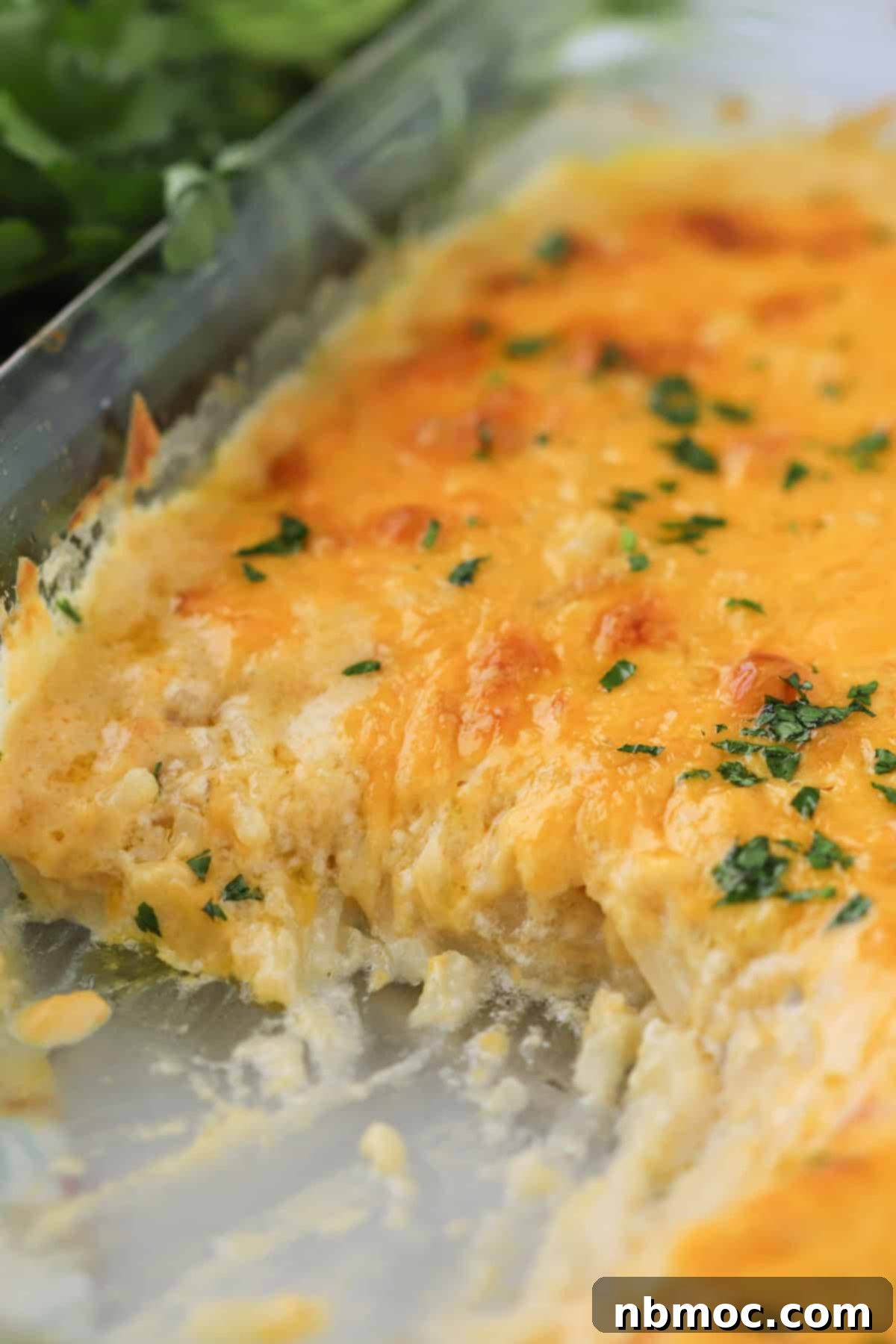 Ultimate Cheesy Potato Bake 4 cheesy potato casserole in a glass baking dish.