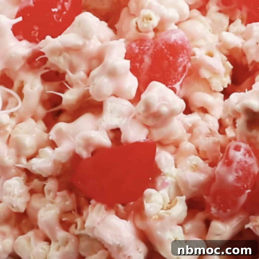 A close-up of festive Cinnamon Bear Popcorn, a white chocolate and marshmallow treat, showcasing its delightful texture.