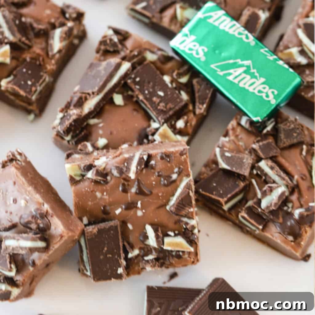 A delightful stack of Andes Mint Fudge, surrounded by Andes mint candies, showcasing a minty homemade treat.