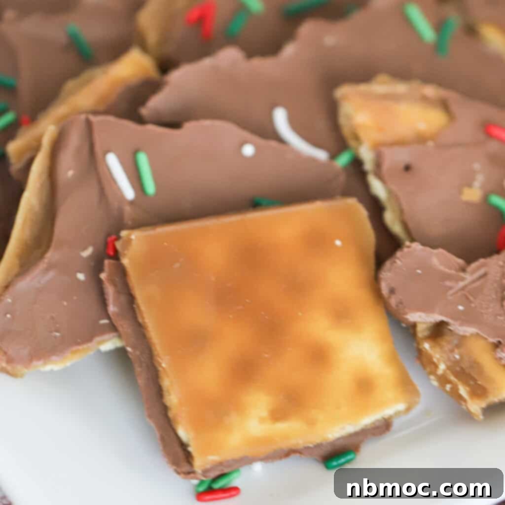 A festive white plate filled with golden Saltine Cracker Toffee, showcasing an easy and delicious Christmas candy recipe.