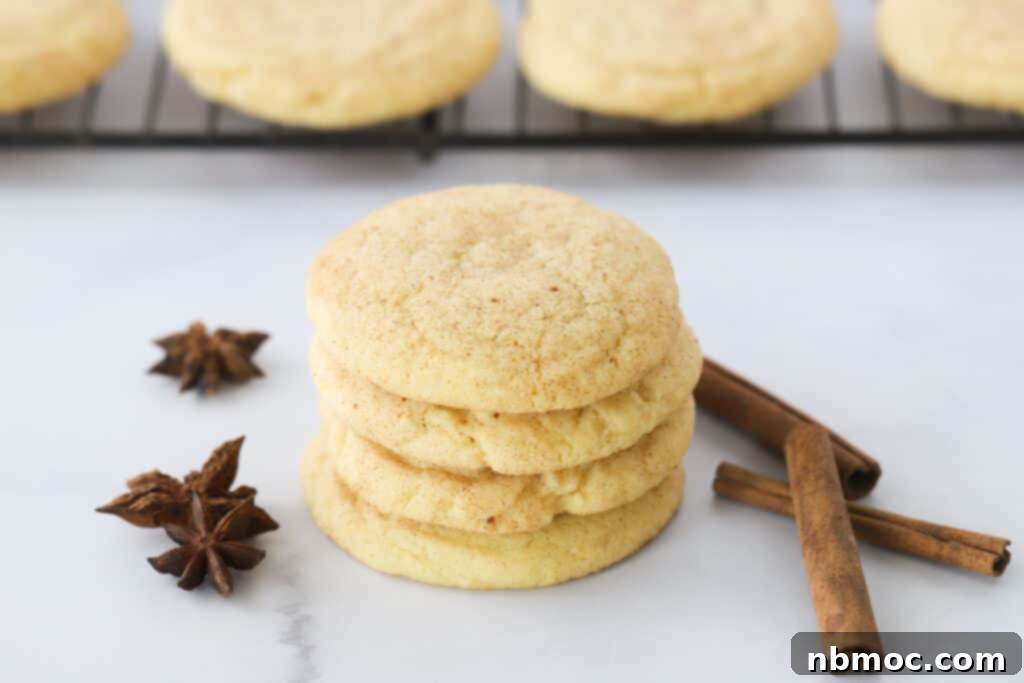 A beautifully composed stack of Pumpkin Snickerdoodle cookies, garnished with cinnamon sticks and star anise, creating an inviting autumn tableau.