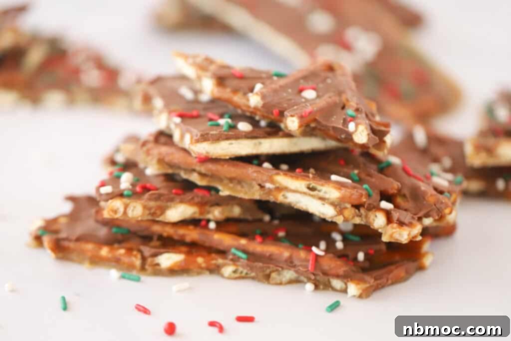 Stacks of delicious pretzel toffee, topped with melted milk chocolate and vibrant red, white, and green sprinkles, embodying the festive spirit of Christmas candy.