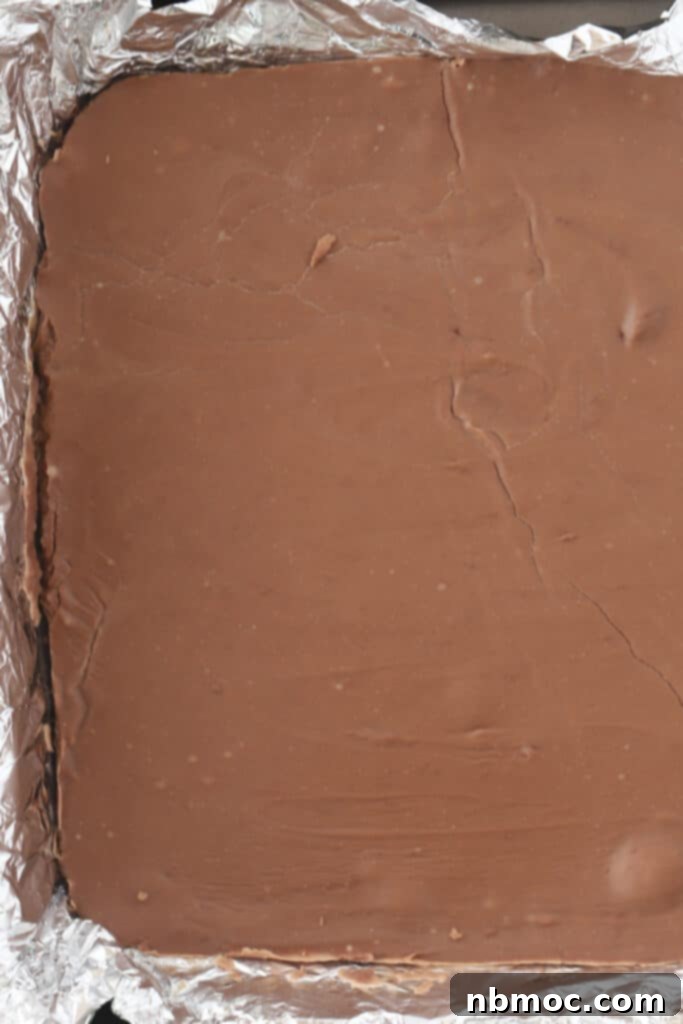 A baking pan filled with freshly poured, unset chocolate fudge, ready for chilling.