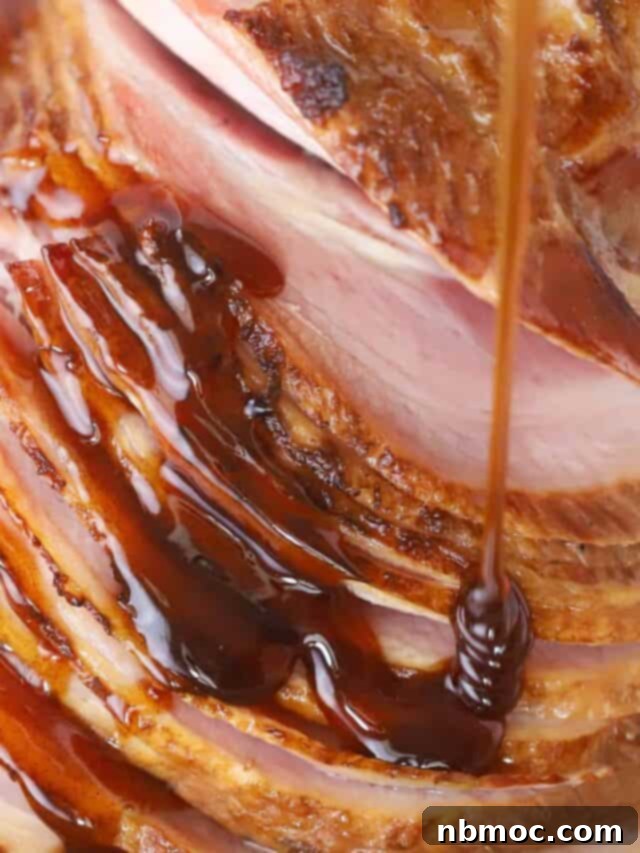 A beautifully spiral sliced ham generously drizzled with a rich, golden honey glaze, ready to be served.