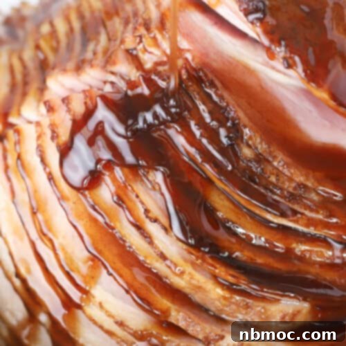 A stunning honey-glazed spiral ham, perfectly cooked and ready to be carved, showcasing a rich, caramelized exterior.