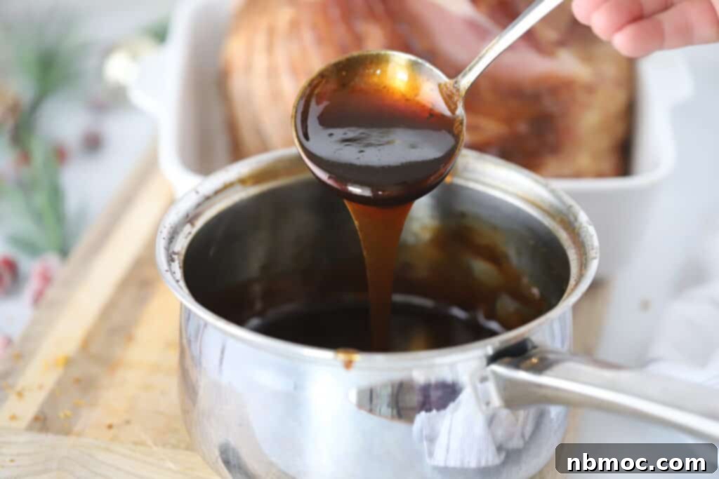 A ladle spooning ham glaze in a sauce pot.
