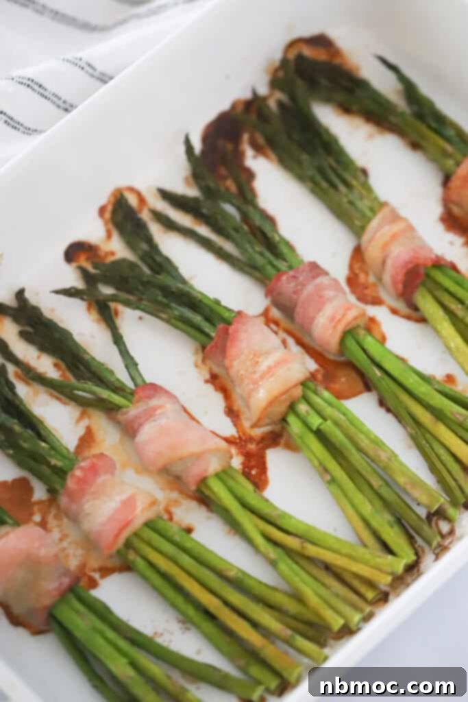 Crispy Bacon Asparagus Bundles 3 Bundles of asparagus wrapped with bacon cooked in a baking dish. asparagus bacon recipes.