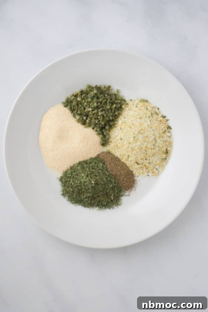A close-up view of the key ingredients for making an easy homemade Ranch Dressing Mix, including dried herbs, garlic salt, onion powder, and black pepper, laid out on a kitchen surface.