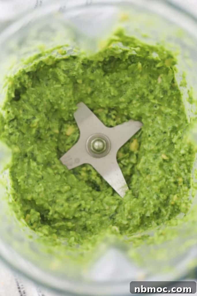 Bright green fresh pesto sauce in a blender. 