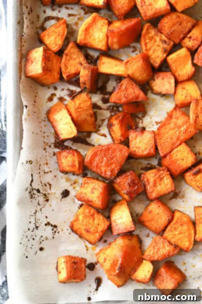 Smoky Chili Sweet Potato Cubes 2 A baking sheet full of spicy roasted sweet potatoes cut into cubes.