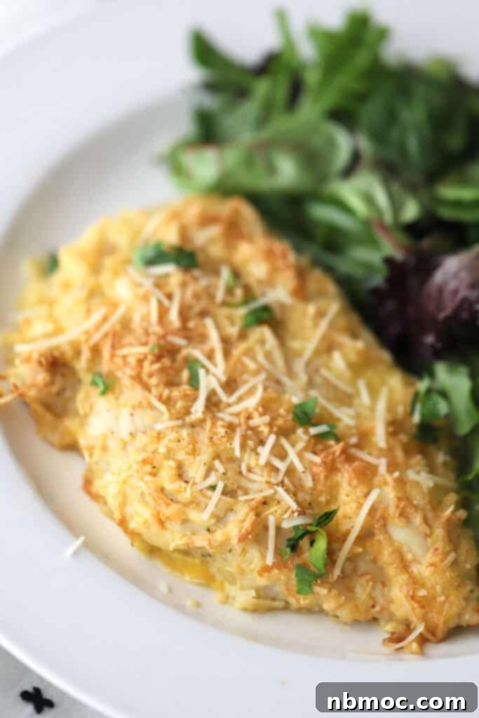A white plate with Parmesan ranch crusted chicken and a side salad.