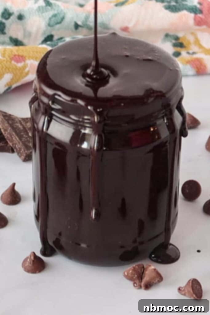 Homemade chocolate syrup overflowing from a glass jar, ready to be enjoyed.