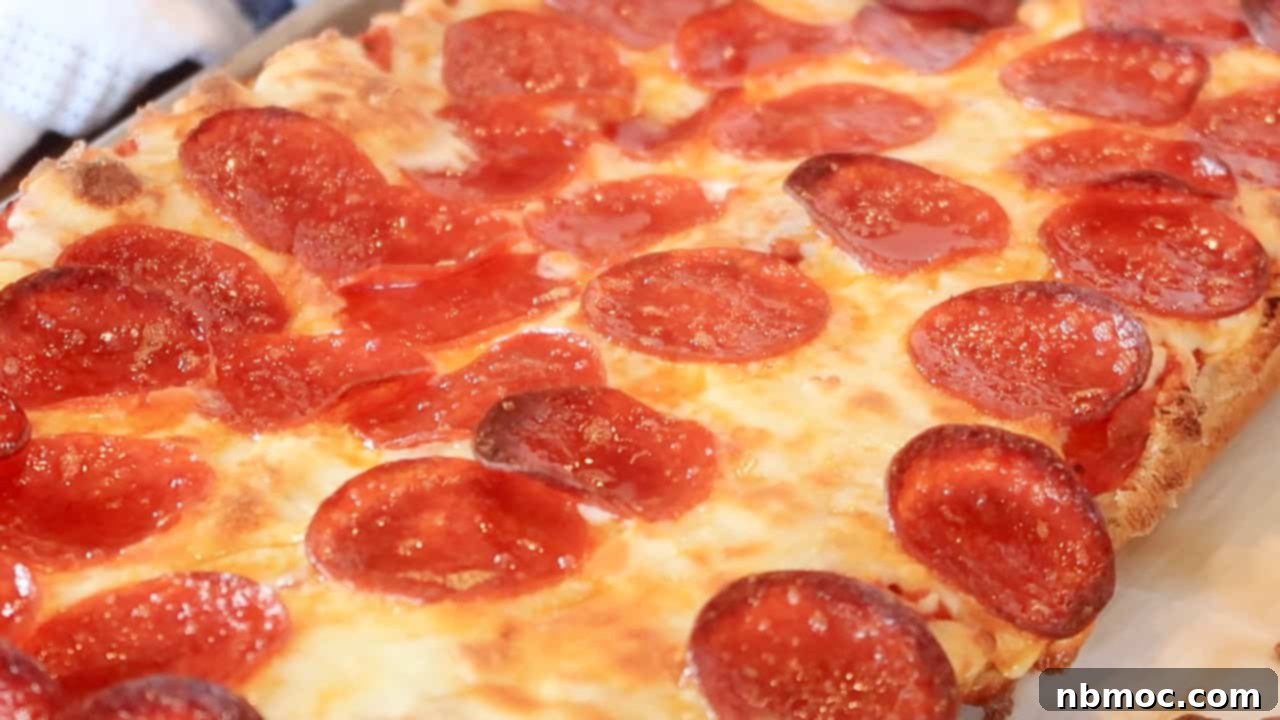 Effortless French Bread Pizza 4 Pepperoni and cheese baked on top of French bread cooling on a sheet tray.