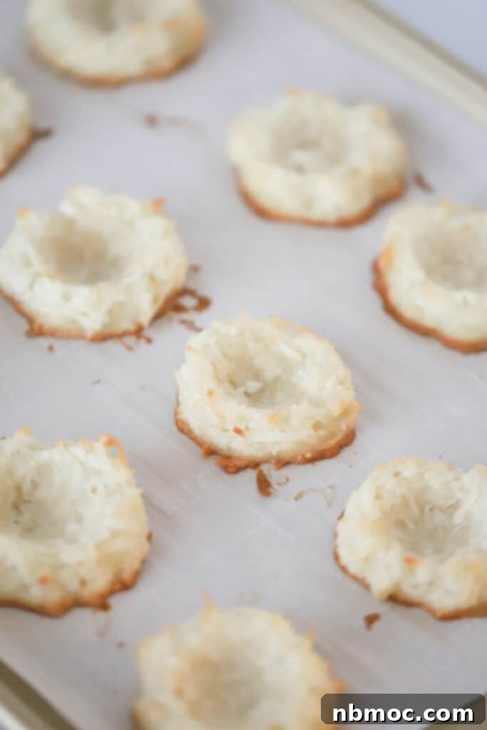 Adorable Coconut Macaroon Easter Nests 4 Baked Easter coconut macaroons on a sheet tray. No bake easter treats.