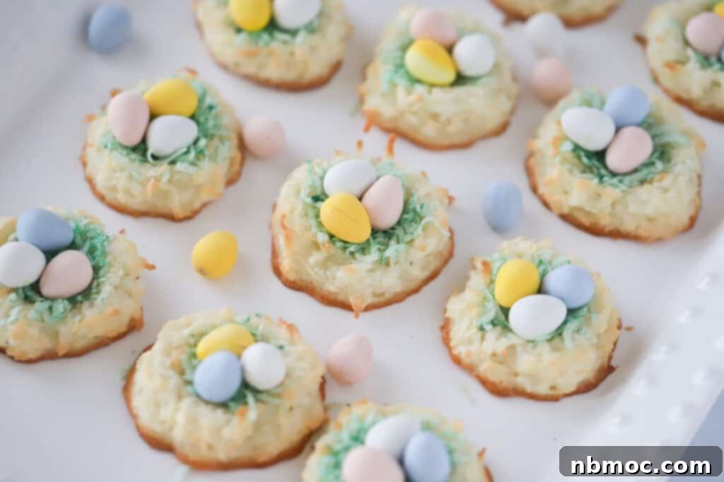 Adorable Coconut Macaroon Easter Nests 5 A tray full of coconut macaroons with a tiny nest in the center filled with colorful candy eggs.