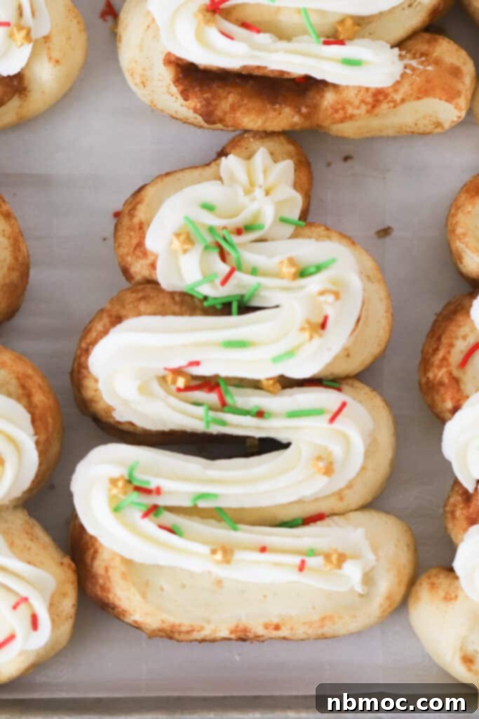 Cinnamon rolls shaped like christmas trees on a sheet tray, decorated with frosting and sprinkles. Christmas morning cinnamon rolls, cinnamon rolls Christmas, 