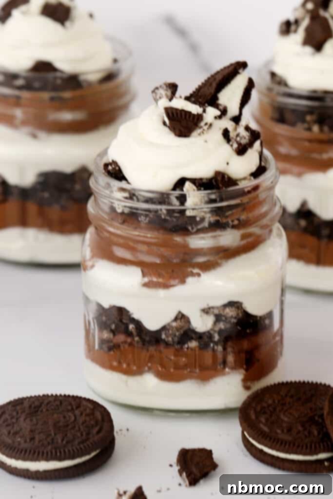 A rich chocolate parfait layered with Oreo crumbles and whipped cream, a decadent dessert.