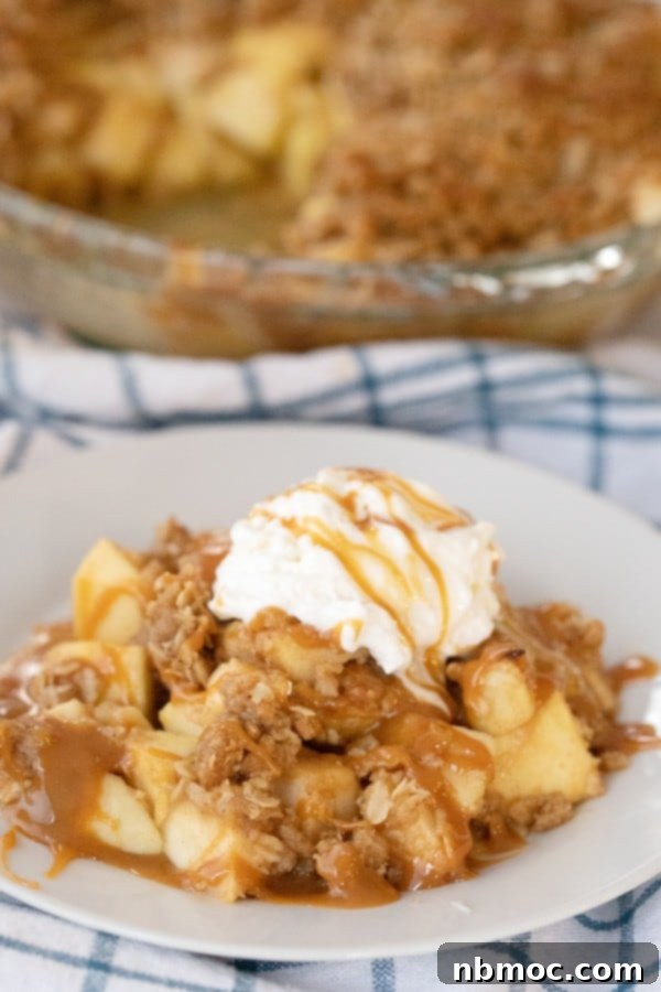 Caramel apple crisp with a golden oat topping, served warm, a comforting fall dessert.