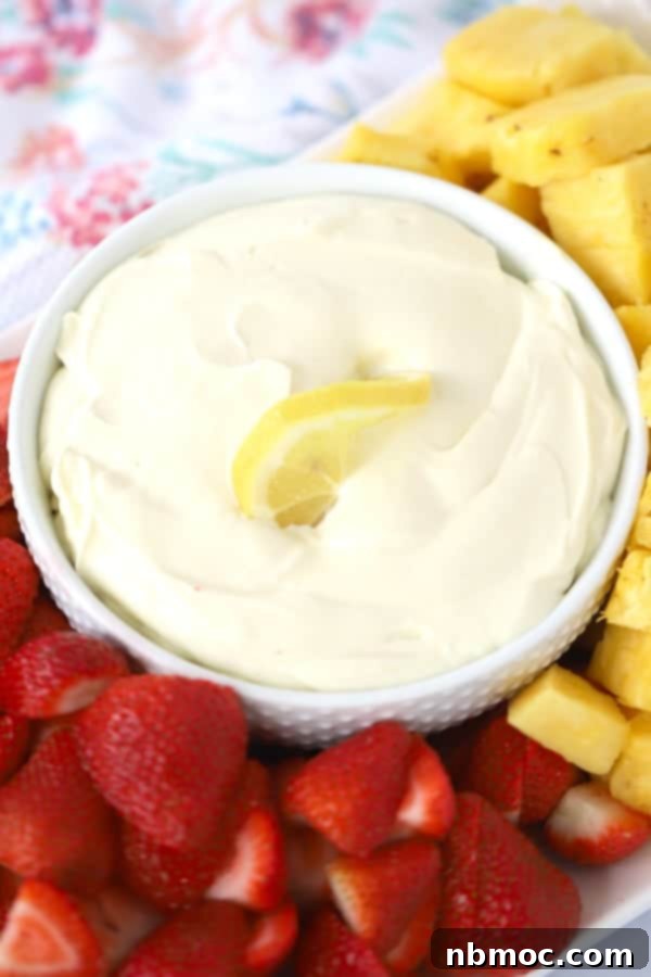 Lemon cheesecake fruit dip in a bowl, garnished with lemon zest, an easy and refreshing dip.