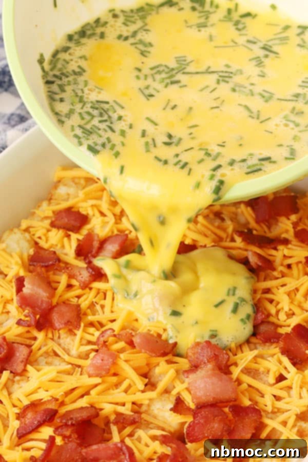 A hearty baked tater tot casserole, bubbling with cheese and bacon, an easy potato breakfast recipe for brunch.