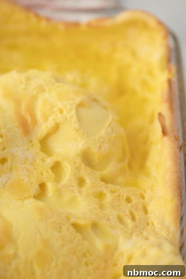 A golden Hootenanny (German pancake) baked in a glass dish, puffed up and ready to serve.