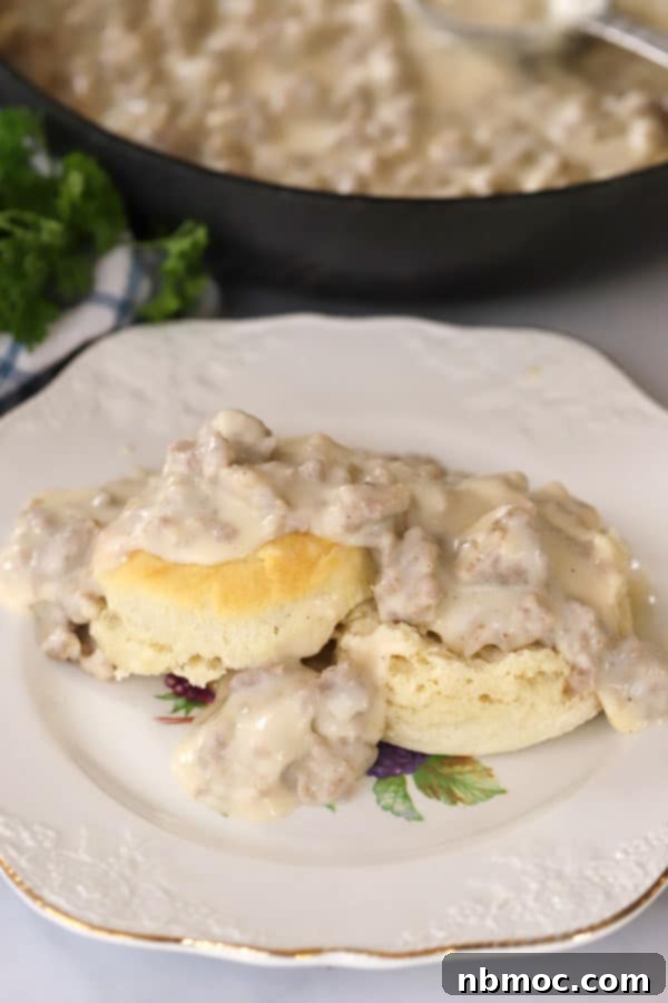 A plate of warm biscuits smothered in creamy sausage gravy, a classic and hearty breakfast recipe.