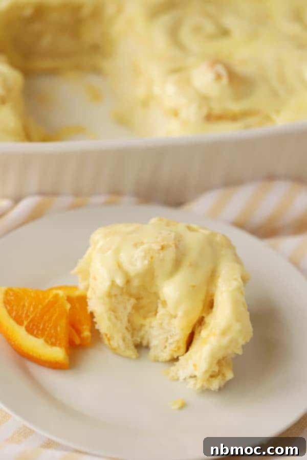 Homemade orange sweet rolls, generously topped with an orange dreamcicle frosting, a vibrant and sweet brunch idea.