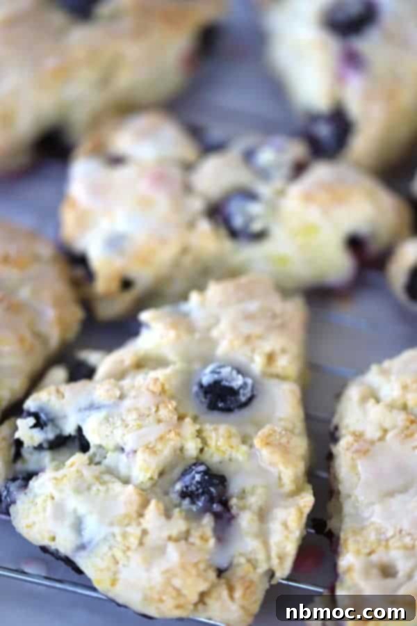 A delicate lemon blueberry scone drizzled with a sweet lemon glaze, perfect for brunch or tea time.