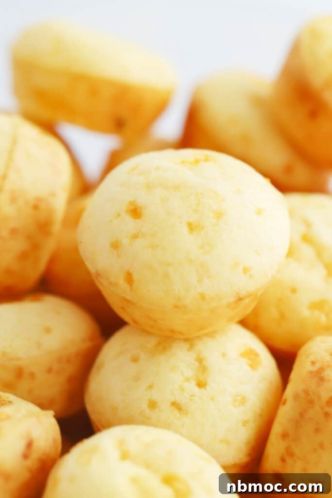 Brazilian cheese bread puffs, golden and cheesy, served in a white bowl.