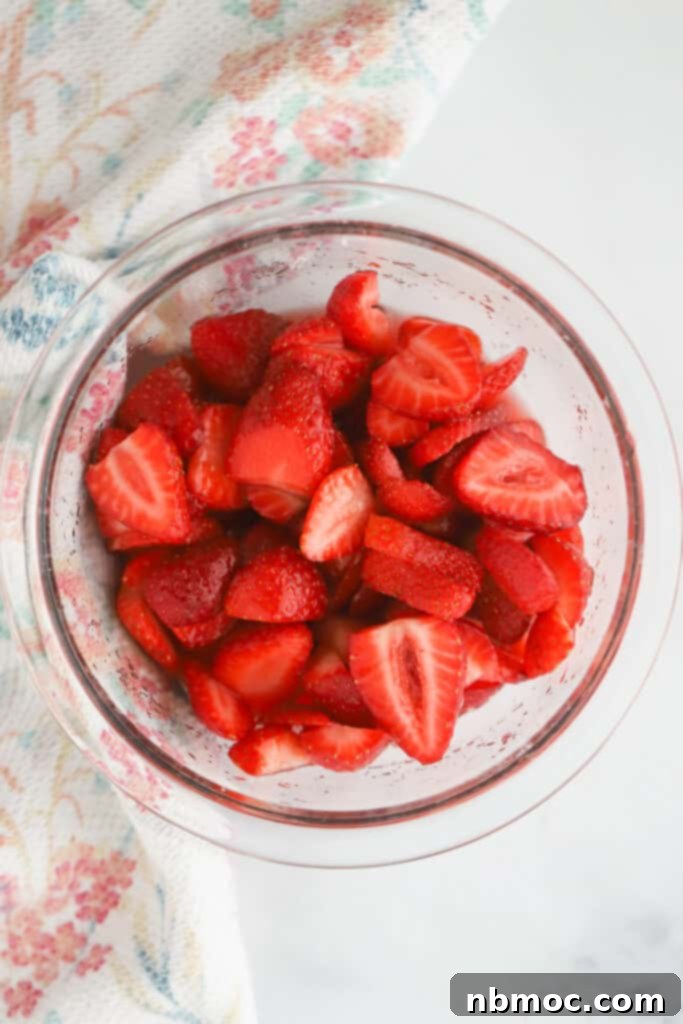 Fresh macerated strawberries in a bowl, glistening and sweet, ideal for topping waffles or pancakes.