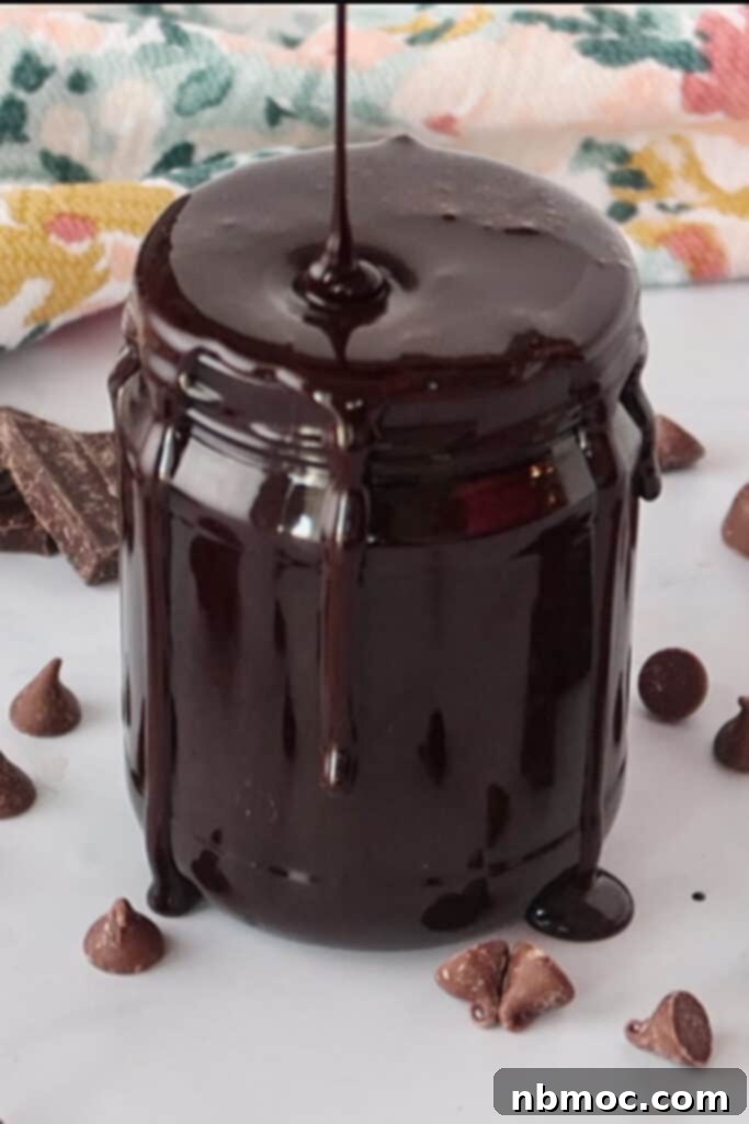 A jar of homemade chocolate syrup, rich and glossy, perfect for desserts and drinks.