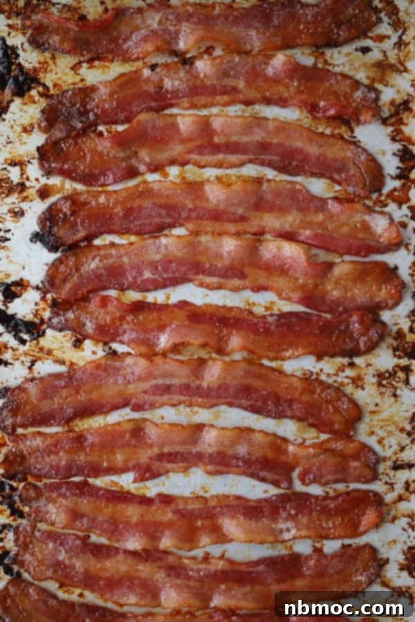 Strips of glistening brown sugar candied bacon on a baking sheet, a perfect crunchy, sweet, and savory addition to any brunch menu.