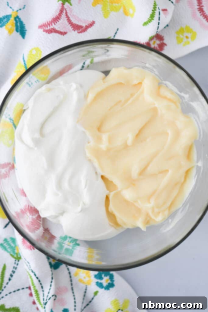 A glass bowl filled with half pastry cream and half whipped cream, about to mix together to make the Custard Cream Puffs filling. vanilla custard filling recipe, custard recipe for cream puffs.