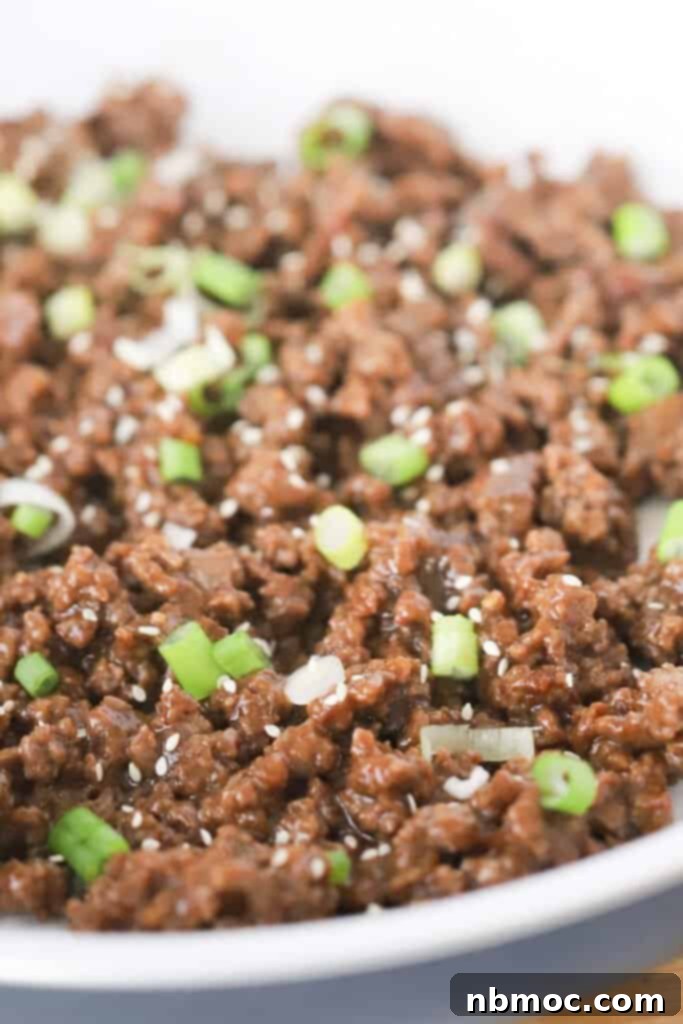 Korean Ground Beef in a large skillet topped with green onions and sesame seeds. 