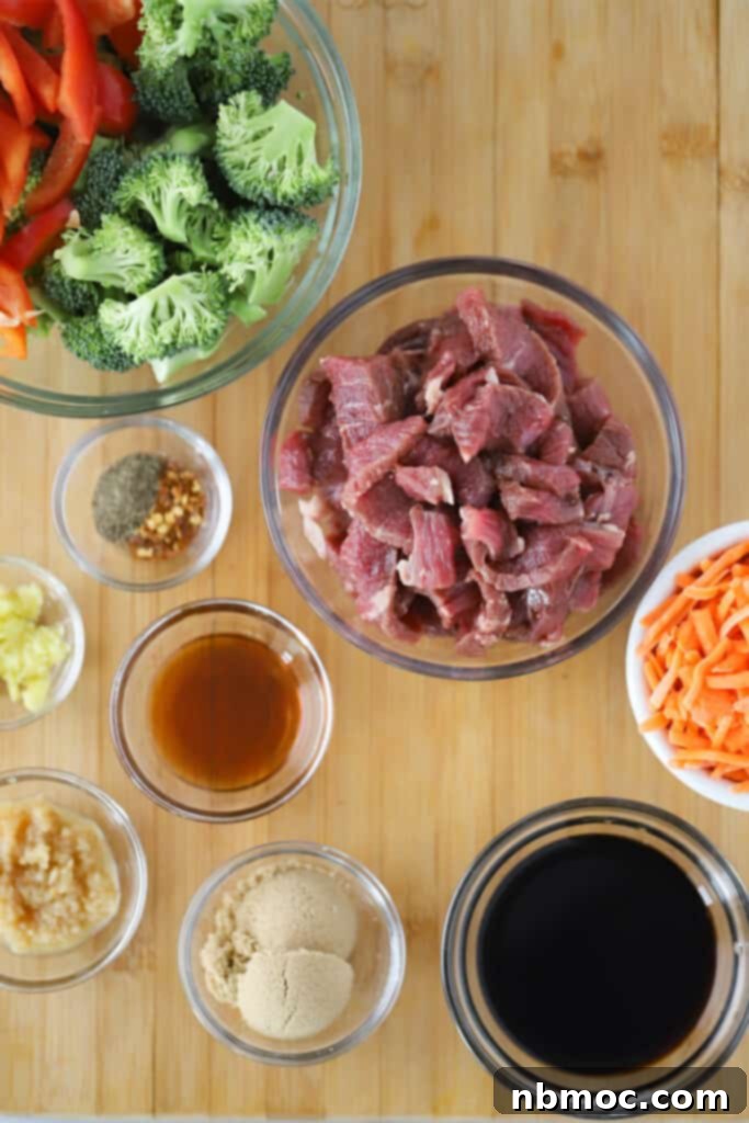 Raw ingredients in small glass bowls and ramekins full of raw steak, cut vegetables and ingredients to make stir fry sauce, neatly arranged on a countertop.