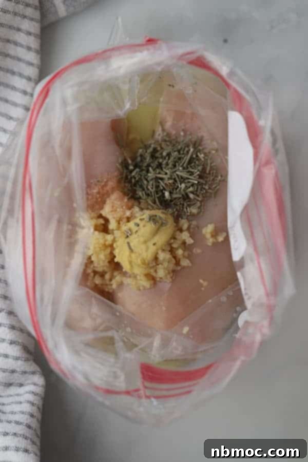 Flavorful Rosemary Garlic Chicken Breast Marinade 2 Marinated rosemary and garlic chicken breast marinade in a ziplock bag, ready for grilling.