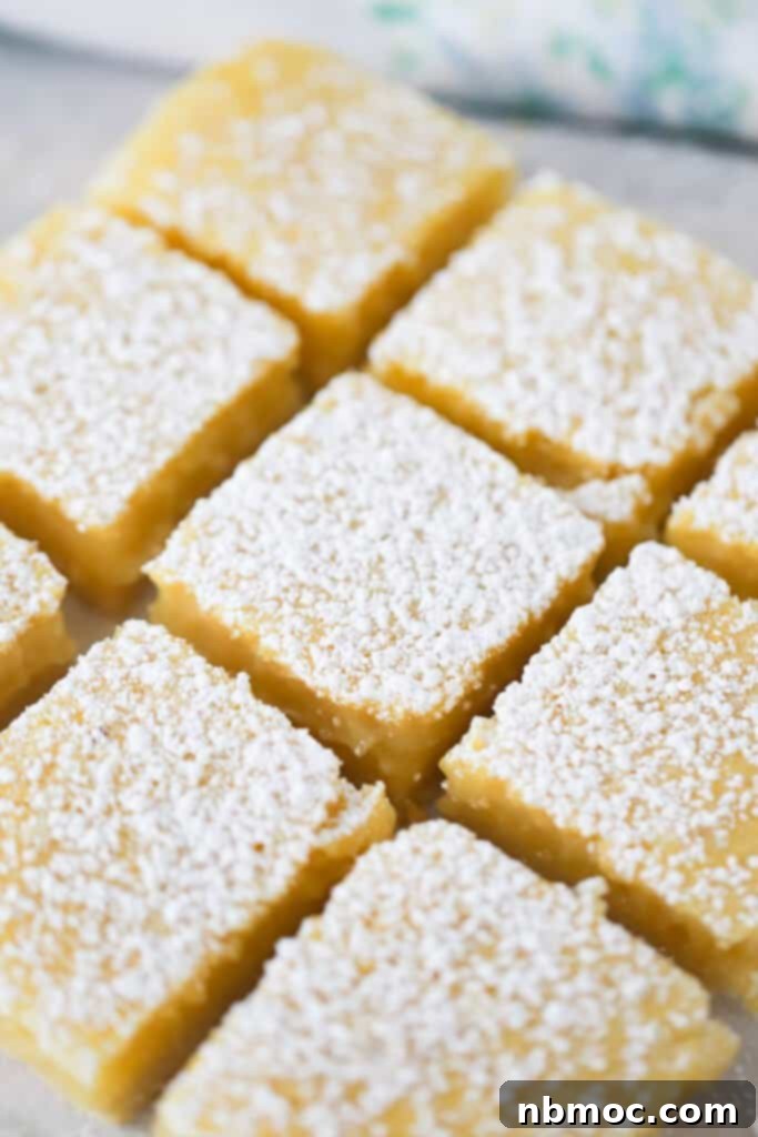 A tray of cut lemon bars dusted with powdered sugar.