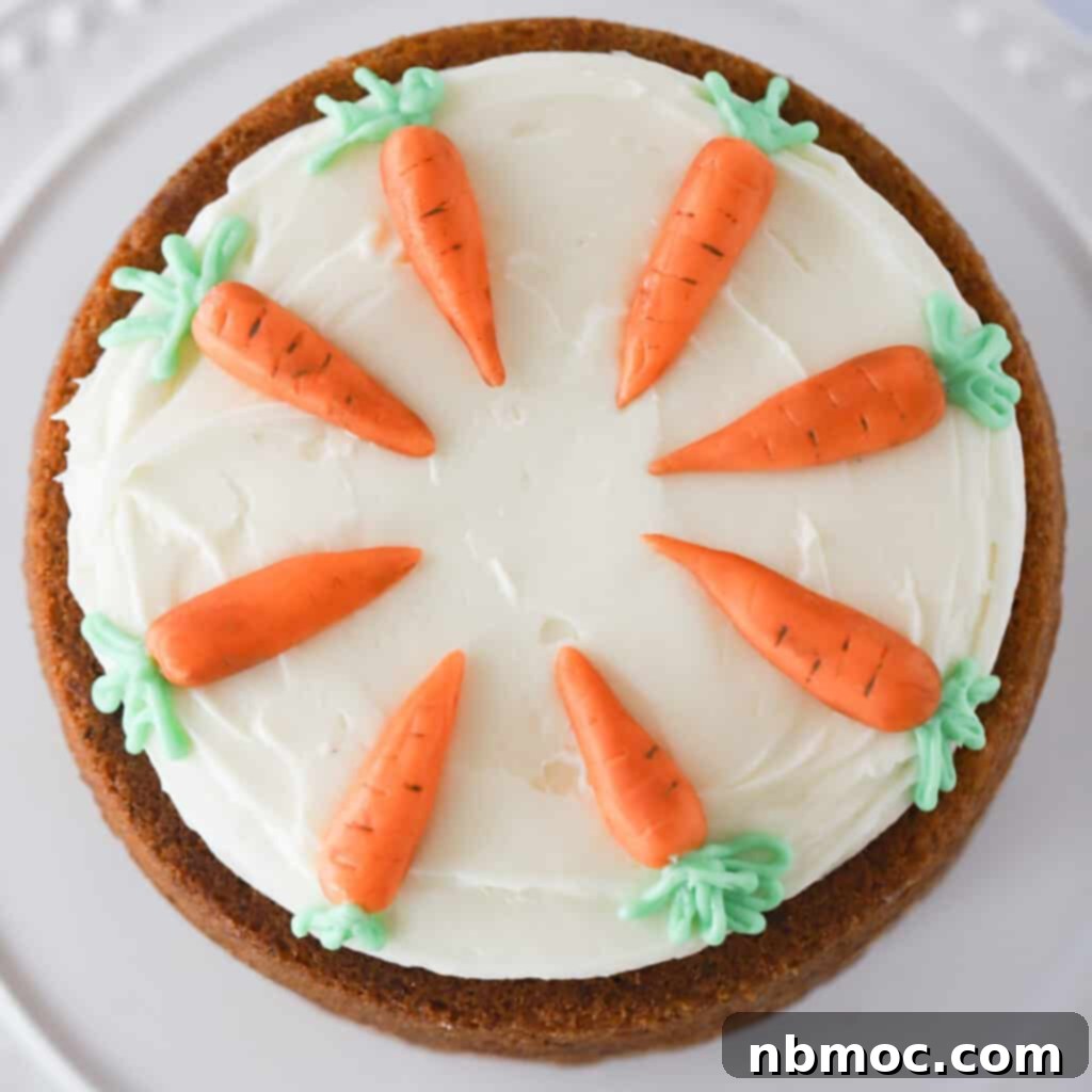 Ultimate Carrot Cake 3 Photo of a decorated carrot cake from above, frosted with cream cheese frosting and carrot decorations.