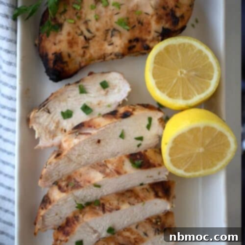 honey mustard chicken with a lemon wedge on a white plate
