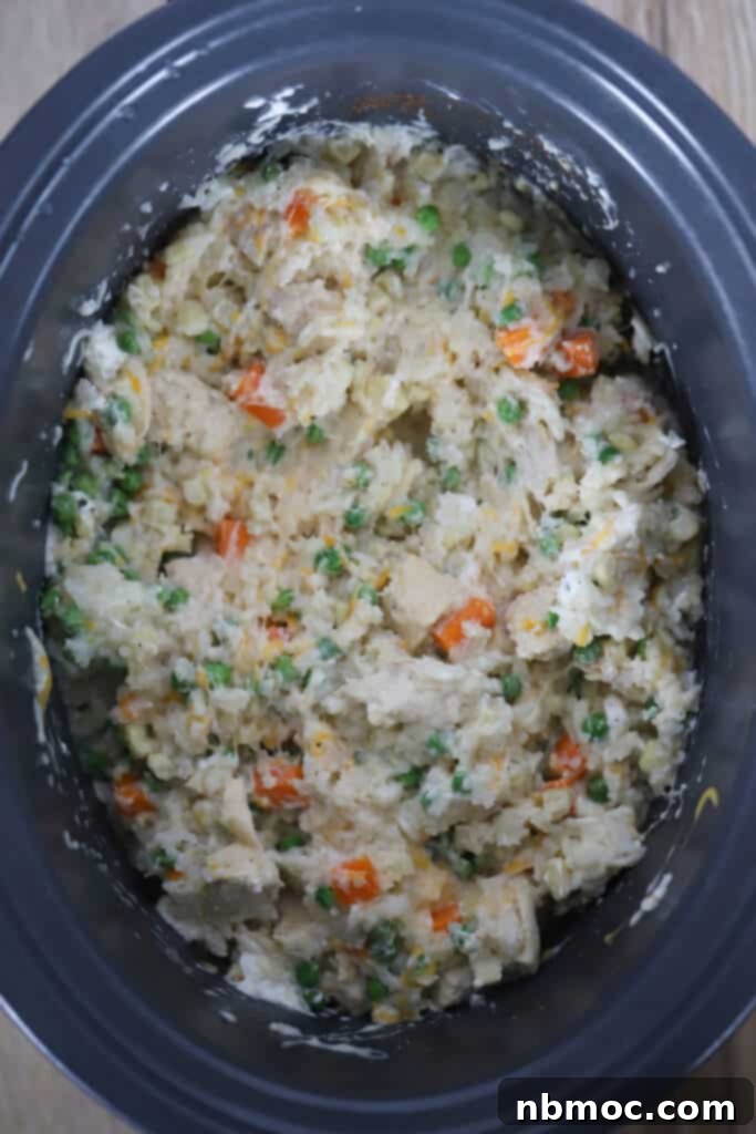 Effortless Cheesy Chicken and Rice Feast 5 A slow cooker filled with the finished Cheesy Chicken and Rice, garnished with fresh herbs, showcasing the creamy texture and integrated vegetables.