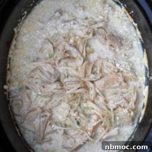 Crockpot Chicken Salsa Verde, shredded chicken in a crockpot with creamy sauce