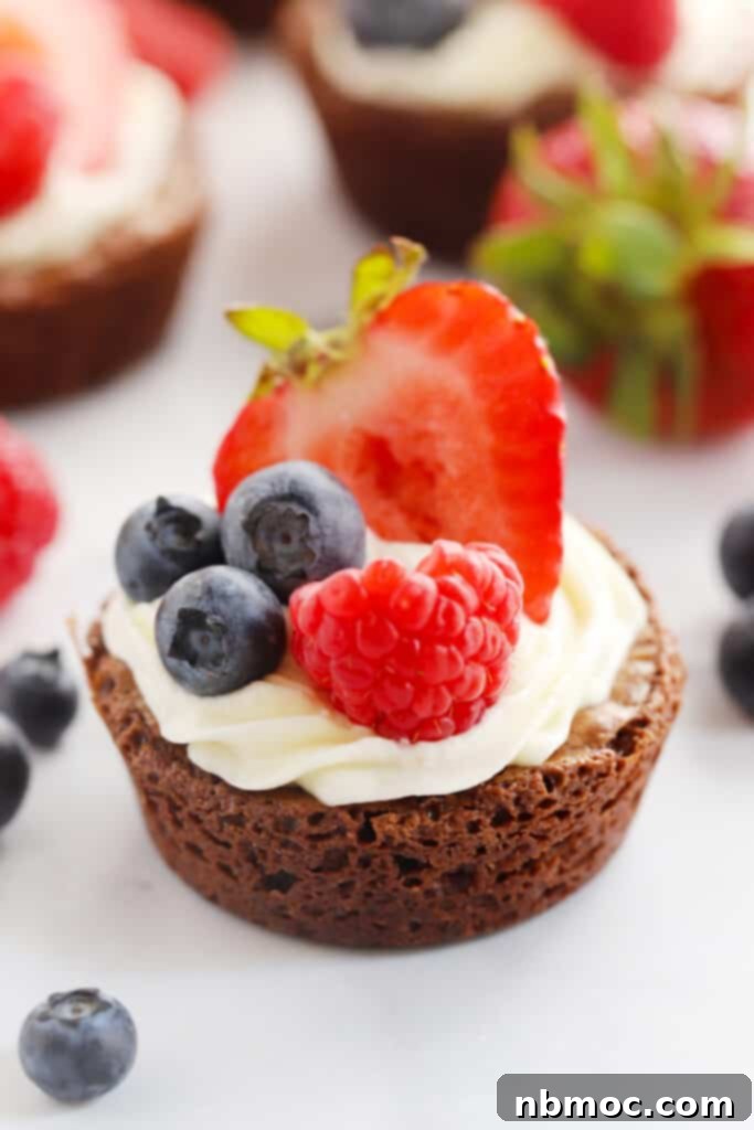 Decadent Brownie Bites topped with fresh blueberries and strawberries, creating a red, white, and blue theme.