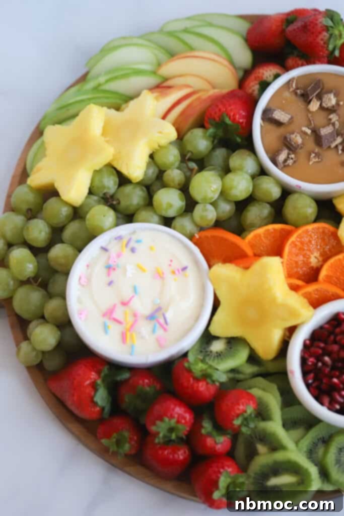 A festive Red, White, and Blue Fruit Charcuterie Board with star-shaped pineapple, berries, and a dip.